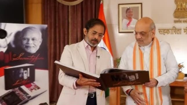 Network18 Group Editor-in-Chief Rahul Joshi presents the coffee table book Modi@75 to Union Minister Amit Shah. following an exclusive interview on the Prime Minister’s 75-year journey and leadership.